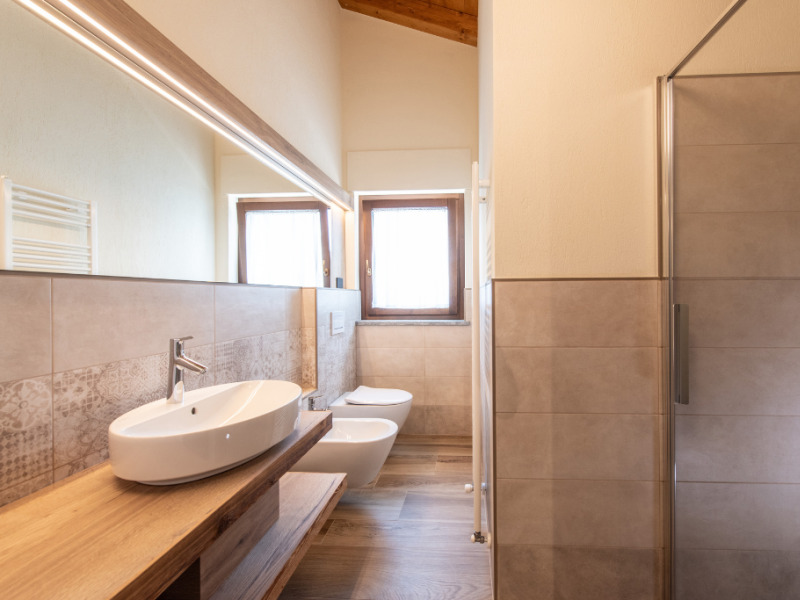 Modernes Badezimmer mit Waschbecken, Bidet und Dusche. Helles Fenster.