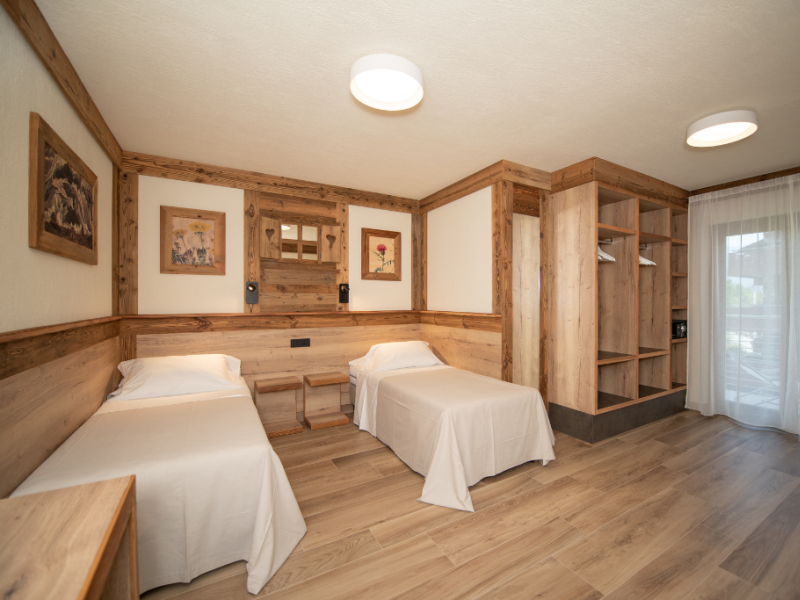 Chambre moderne avec deux lits simples et des meubles en bois.
