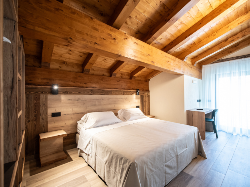 Chambre confortable avec plafond en bois et lumière naturelle.