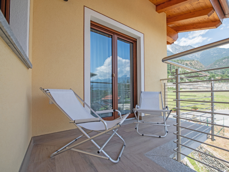 Balcony with two folding chairs and mountain view.
